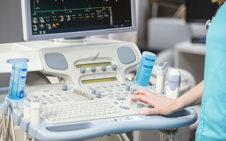 Side view of someone typing on medical equipment